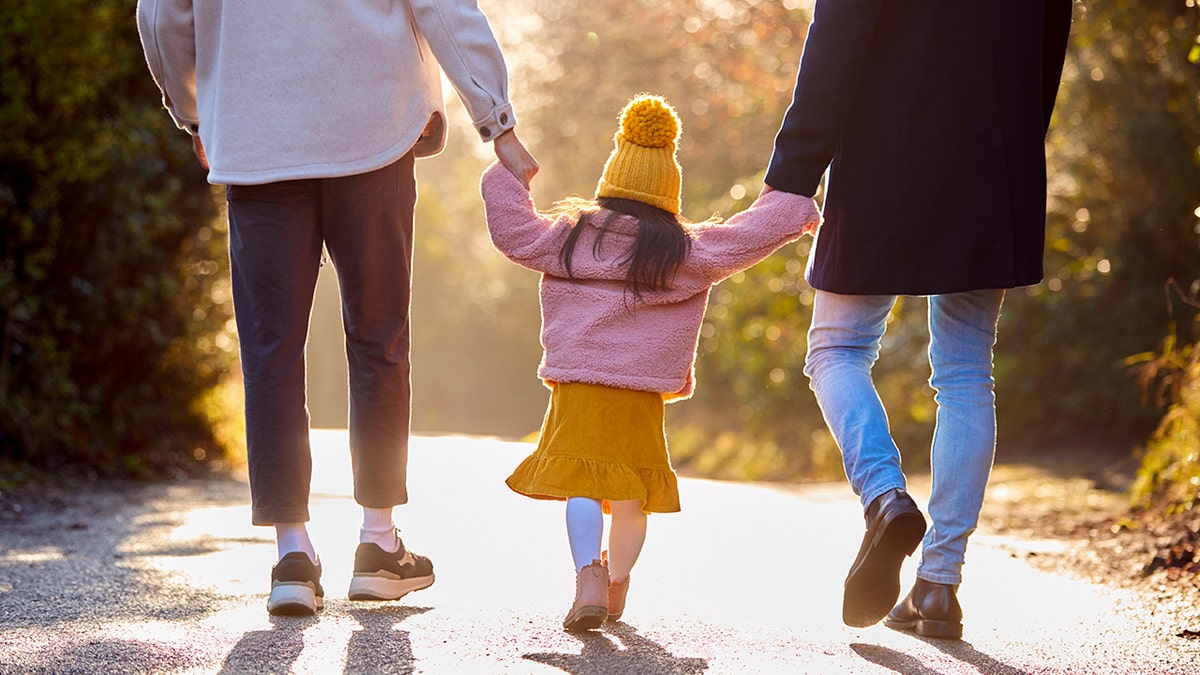 Parents holding hands with a child