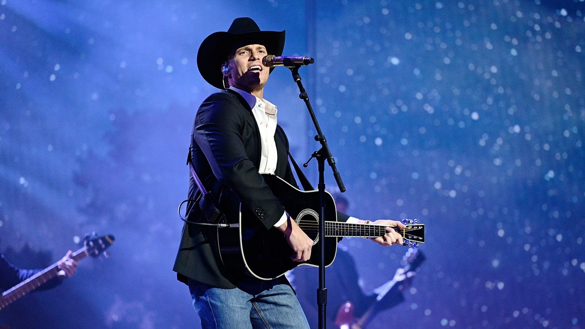 Parker McCollum performing onstage at the Grand Ole Opry House.