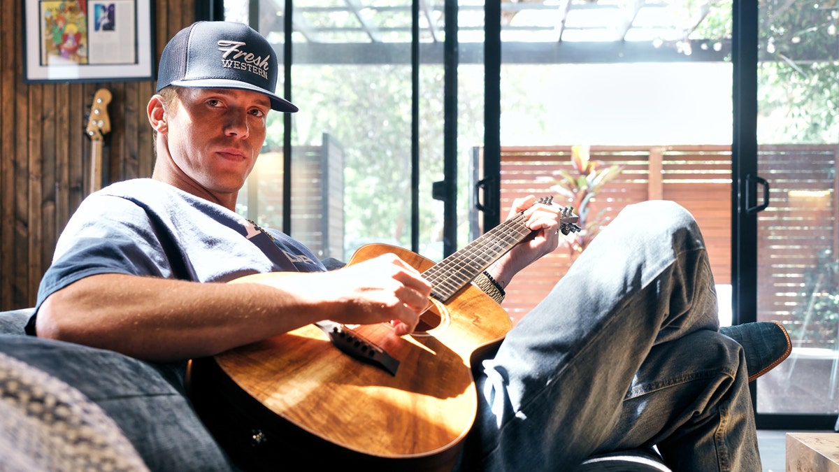 Parker McCollum posing for a portrait inside a recording studio.