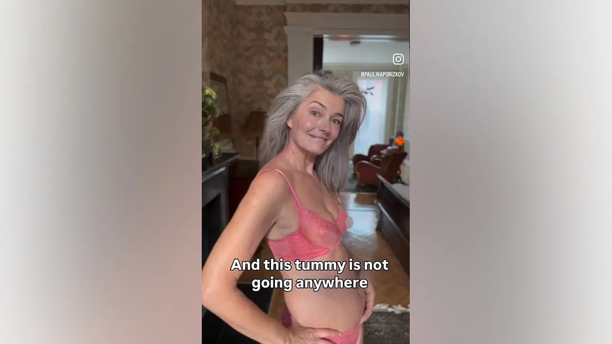 Paulina Porizkova showing her midsection while smiling at the camera.