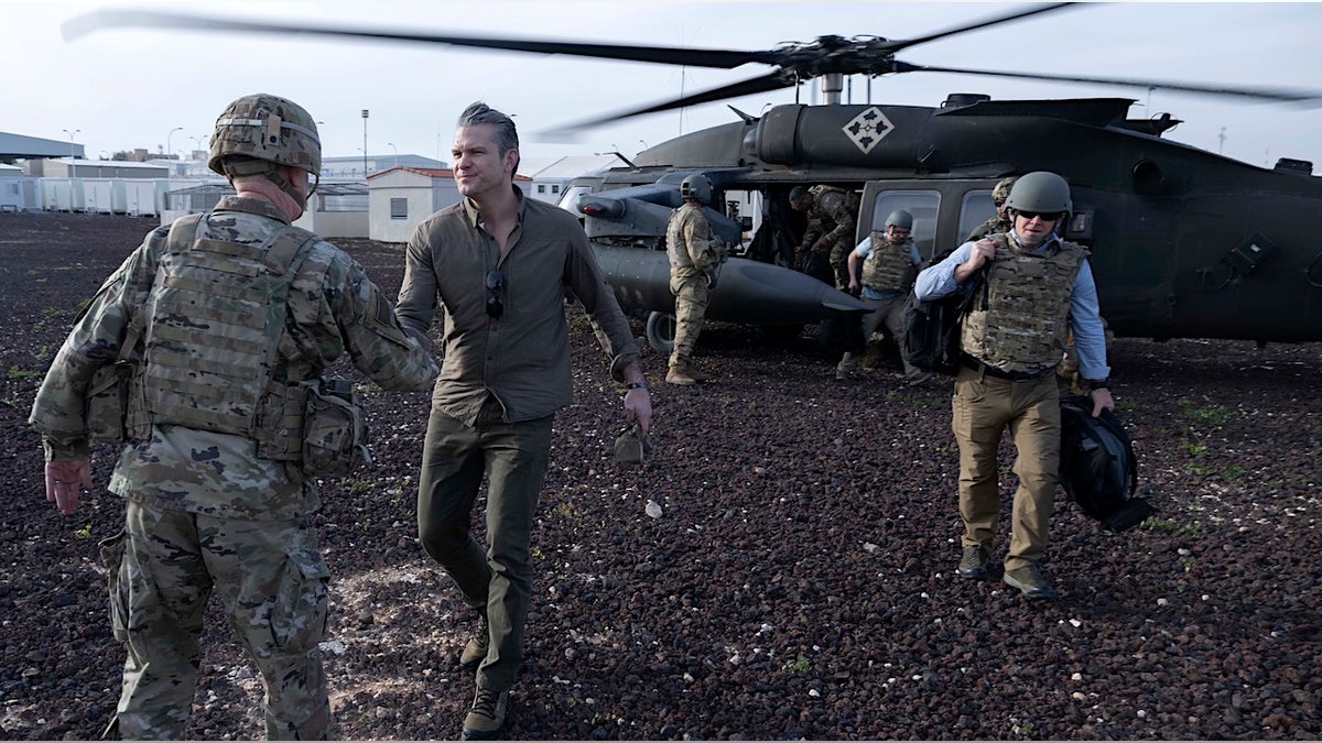 war secretary pete hegseth shakes hands with wartime troops
