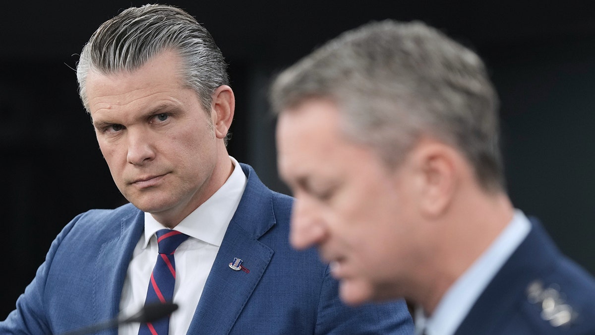 Defense Secretary Pete Hegseth listening to Gen. Dan Caine during a Pentagon press briefing