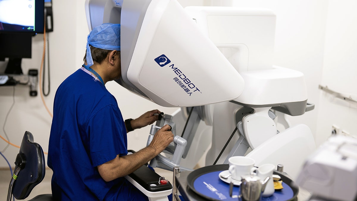 A surgeon uses a robotic surgery terminal to perform a remote surgery.