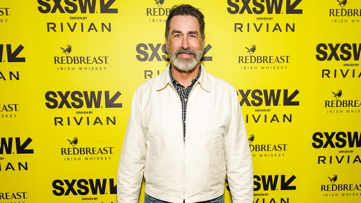 Rob Riggle stands during movie premiere
