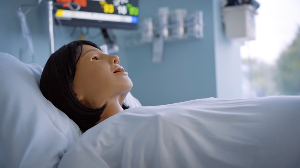 Mama Anne is a high-fidelity childbirth simulator, and it is lying on a hospital bed.