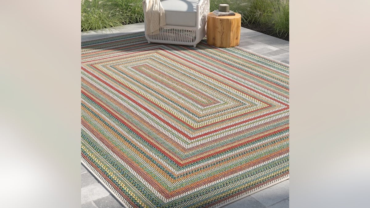 Add interest to a bare patio with a big rug.