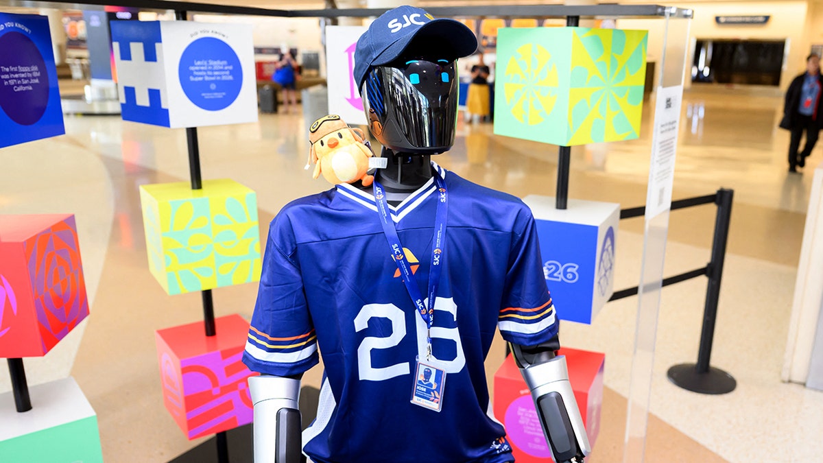 A humanoid robot stands in an airport terminal.