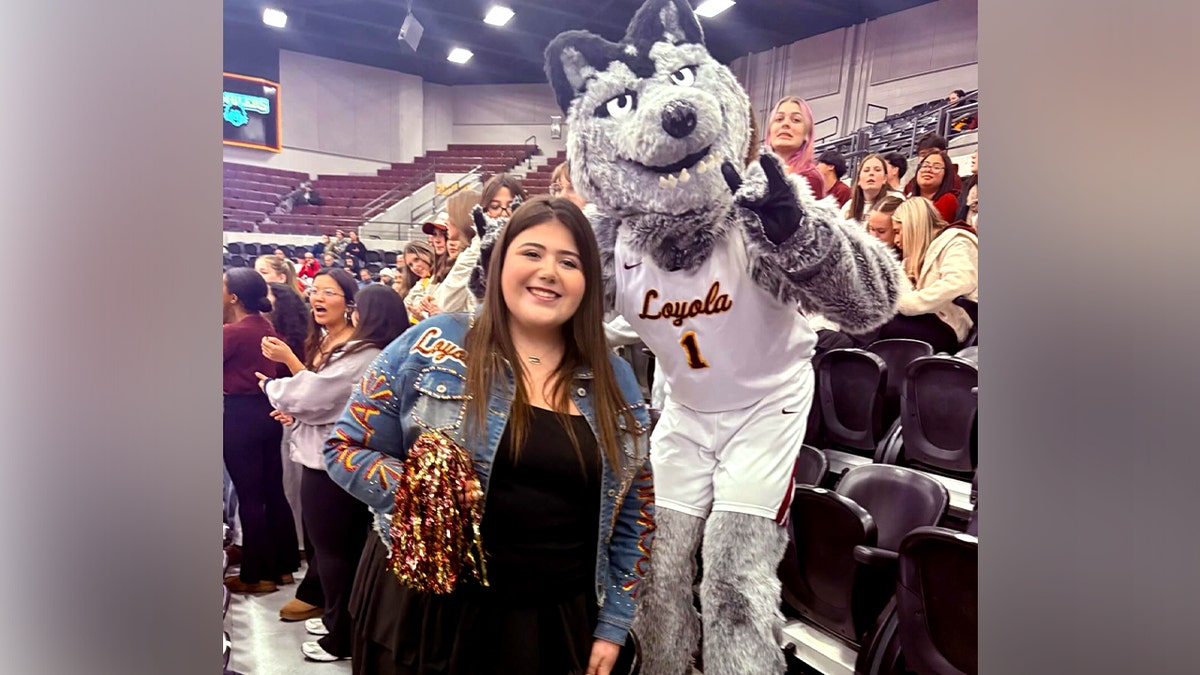 Loyola student Sheridan Gorman poses with Loyola's mascot at a game.