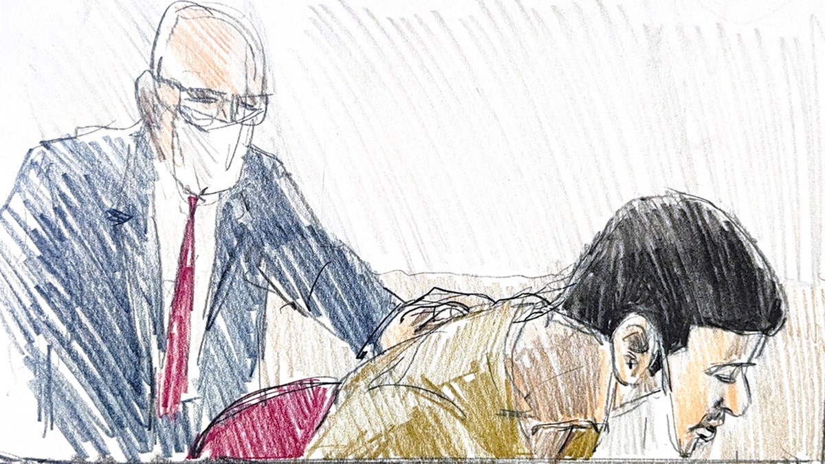 Jose Medina-Medina sitting at a table during a court hearing while a legal professional speaks.