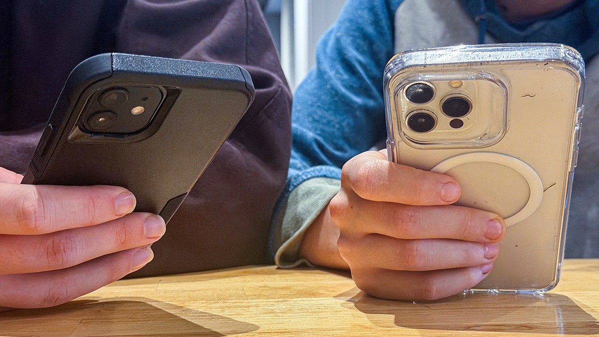 Two people hold smartphones.