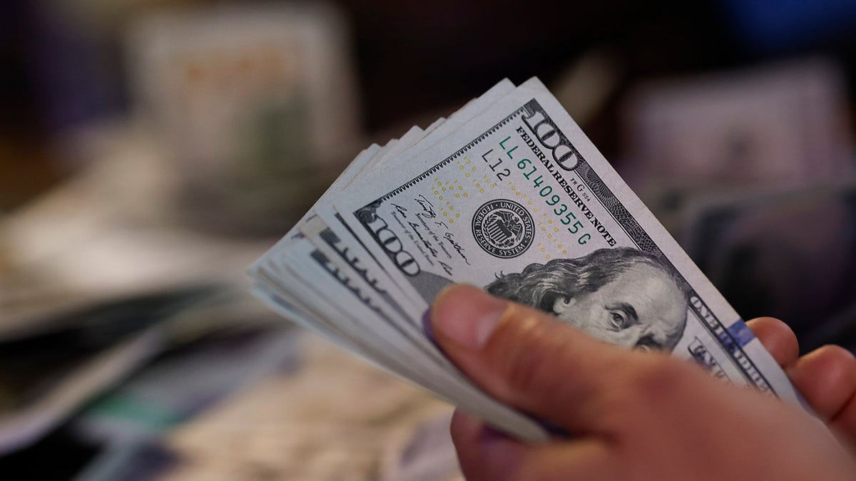 A sports gambler holding U.S. $100 banknotes at Westgate Superbook sports book in Las Vegas
