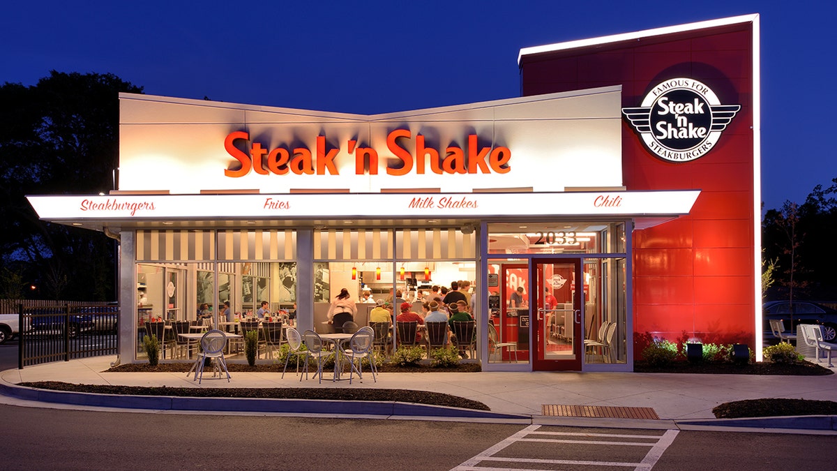 Customers sit inside a Steak 'n Shake restaurant at night.