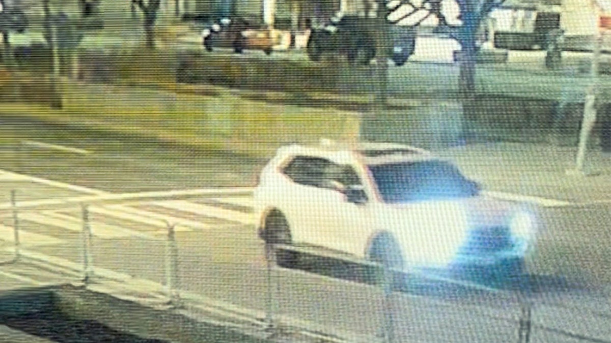 White Honda CR-V driving away.