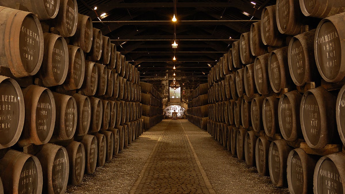 Rows of Barrels in a Large, dimly lit Wine Cellar