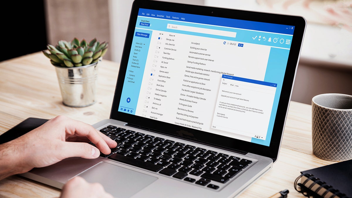 Un laptop appoggiato su una scrivania mostra una casella di posta elettronica sullo schermo.