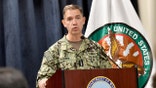 Adm. Charles “Brad” Cooper II addresses reporters at a podium during a briefing at MacDill Air Force Base in Florida.