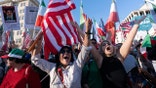 People holding flags and signs while rallying near the White House in Washington, D.C.
