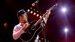 Parker McCollum performing on a stage inside a stadium.
