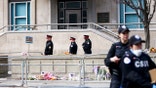 Law enforcement officers stand guard outside a diplomatic facility in downtown Toronto following an early-morning gunfire incident.