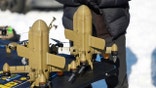 Two tan "Sting" interceptor drones sit on a black table outdoors.