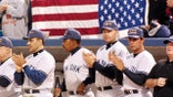 Yankees players applaud wearing FDNY hats