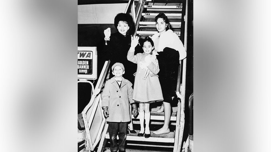 Judy Garland sitting with her children Liza, Lorna, and Joe.