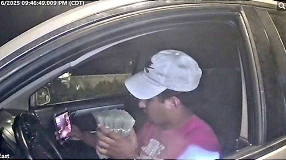 Suspect inside a vehicle holding cash allegedly stolen in ATM jackpotting scheme