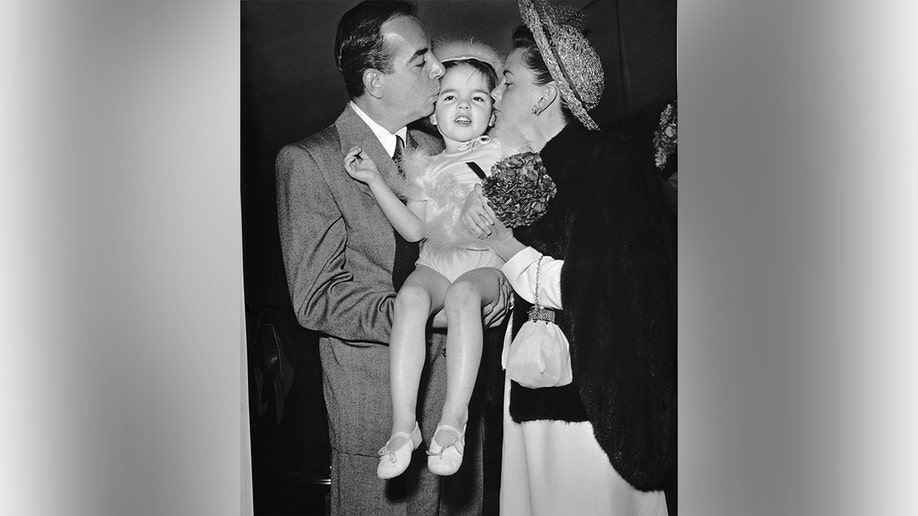 Liza Minnelli, Judy Garland, and Vincente Minnelli sitting together in a group portrait.