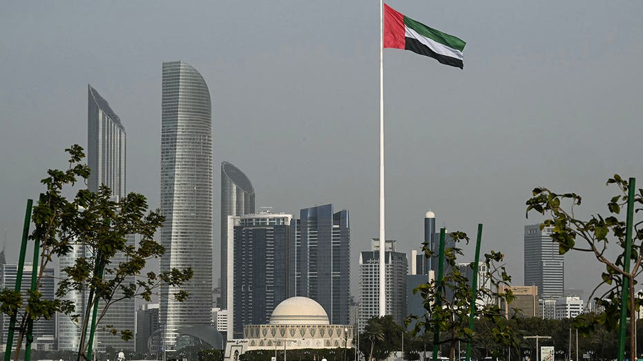 The Emirati flag fluttering in Abu Dhabi against a clear sky