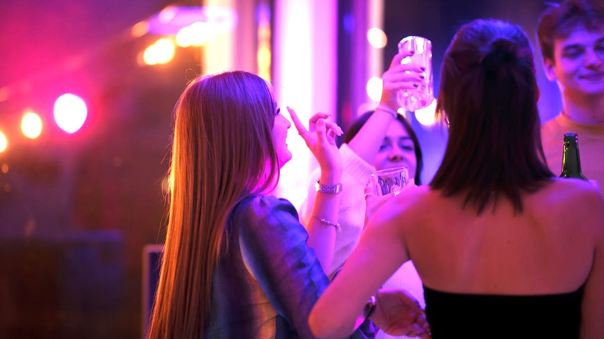 Young women dancing and drinking at party