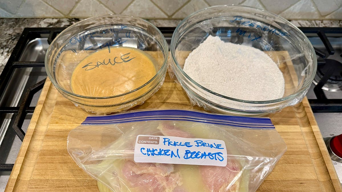 Image of cooking ingredients, including flour mixture, egg mixture, chicken