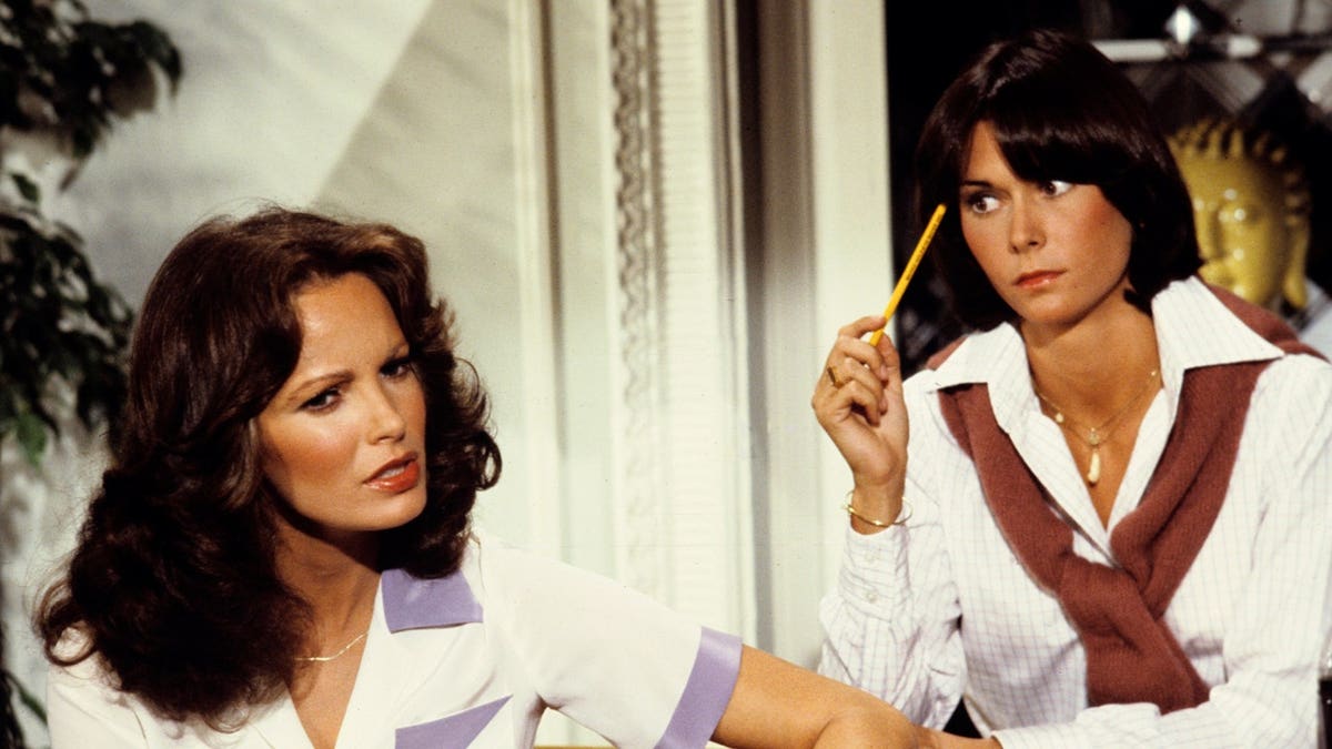 Jaclyn Smith and Kate Jackson sit next to each other.