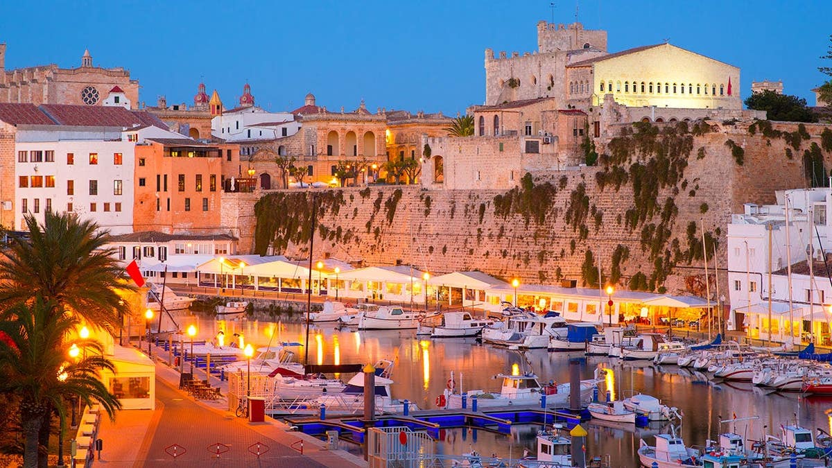Majorca, Menorca and Ibiza want to cap visitor numbers as overtourism surges 4 Menorca marina at sunset with town hall and cathedral visible