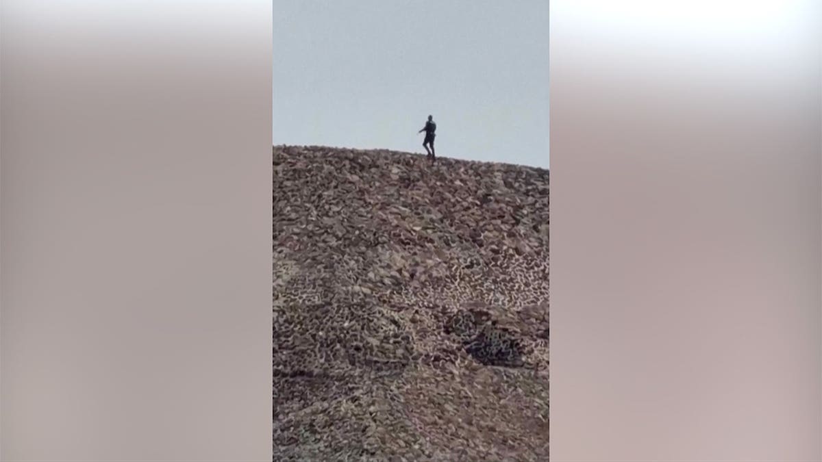 Gunman walks connected  pyramid