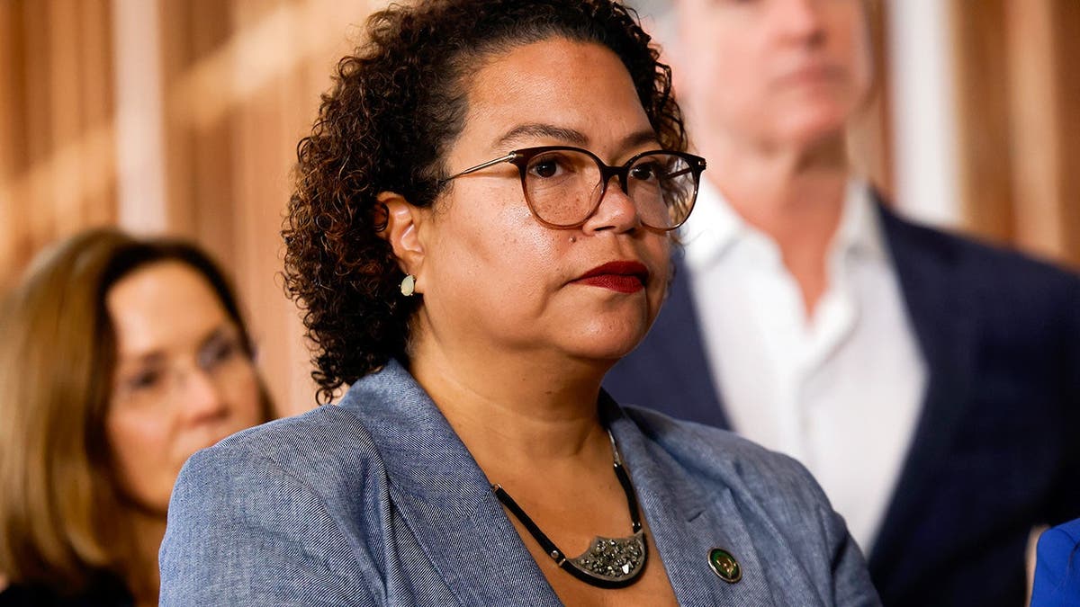 Mia Bonta stands at a press conference alongside Gavin Newsom and other leaders at the BACS REGIS Center.