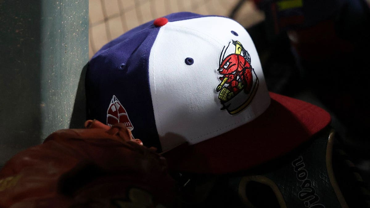 A Portland Sea Dogs cap on a surface during a baseball game.