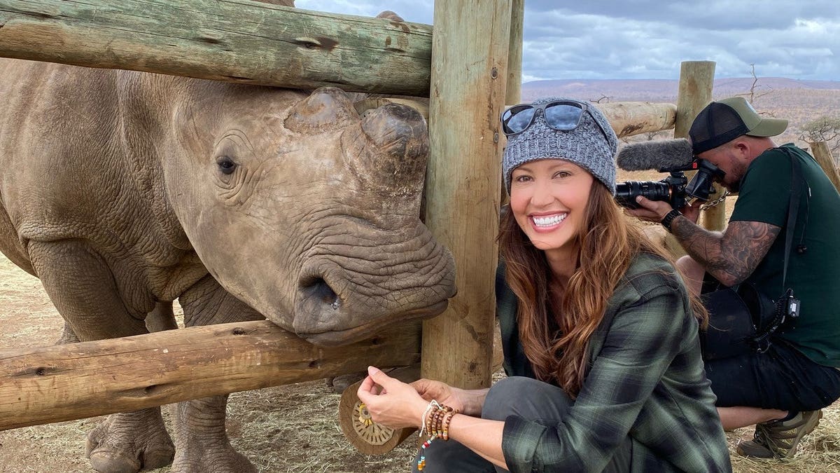 Shannon Elizabeth posing with a rhino.