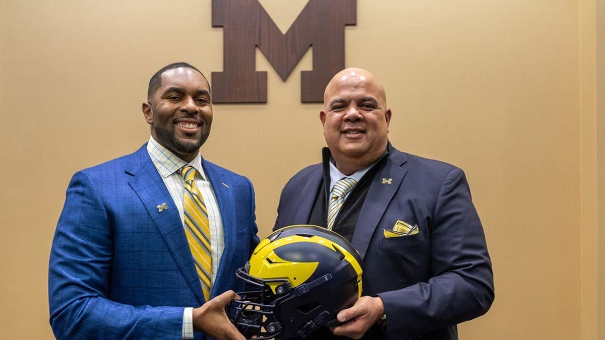 Sherrone Moore stands next to Warde Manuel