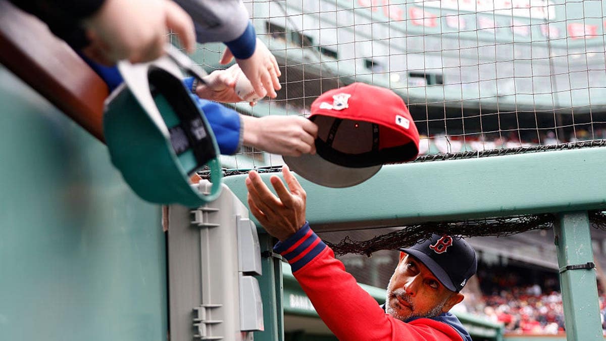 Boston Red Sox manager Alex Cora signing autographs for young fans at Fenway Park