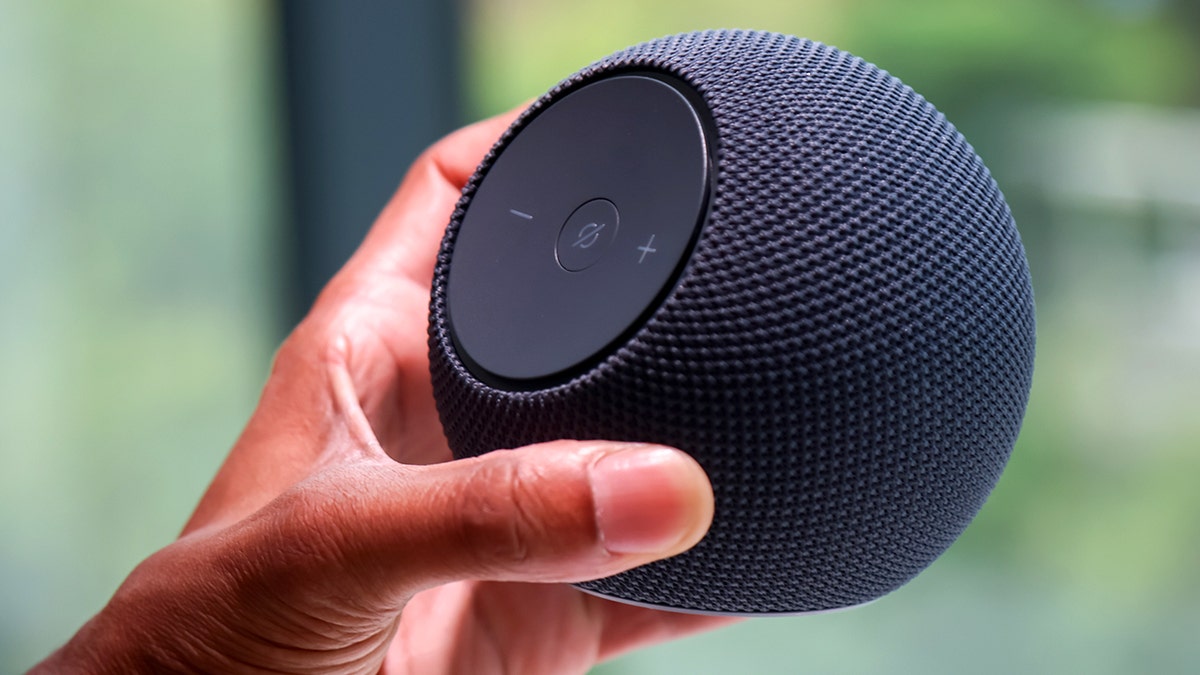 A person holds an Amazon Alexa device.