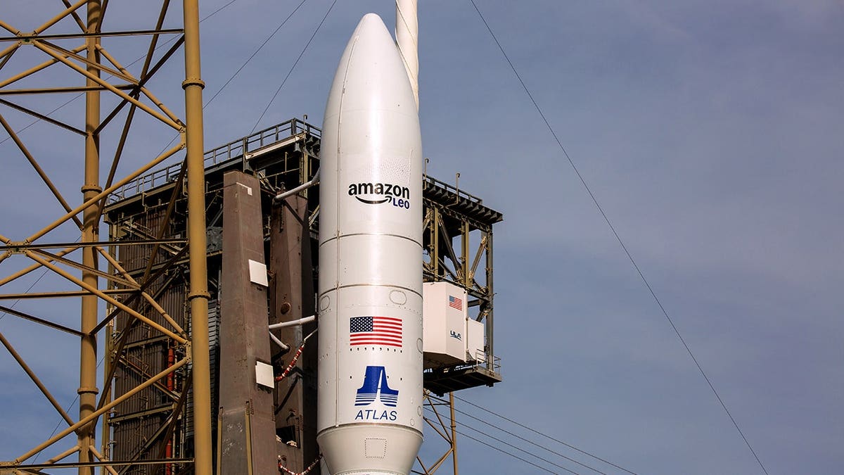 A rocket with Amazon Leo's branding stands on a launch pad.