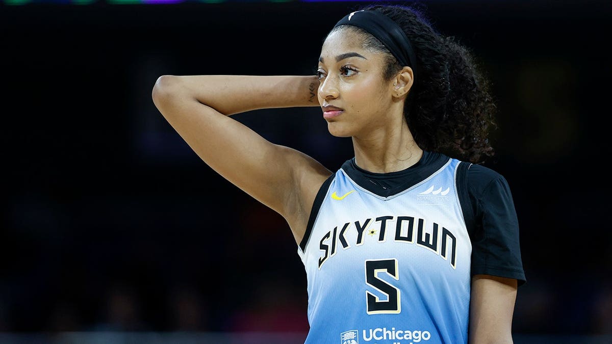 Angel Reese walking on the basketball court during a WNBA game.