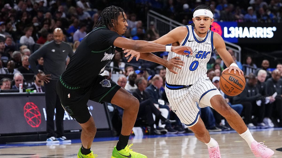 Anthony Black dribbling basketball against Julian Phillips at Kia Center