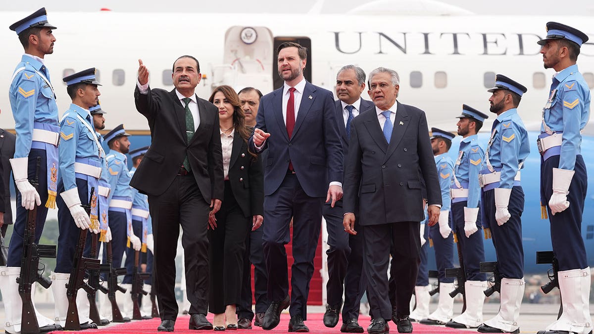 U.S. Vice President JD Vance (C) walks with Pakistan's Chief of Defence Forces and Chief of Army Staff Field Marshall Asim Munir (L)