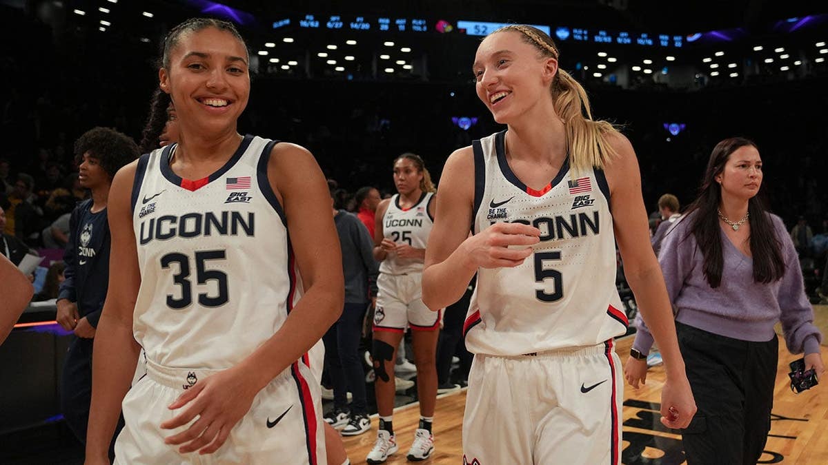 Azzi Fudd and Paige Bueckers celebrating on basketball court at Barclays Center