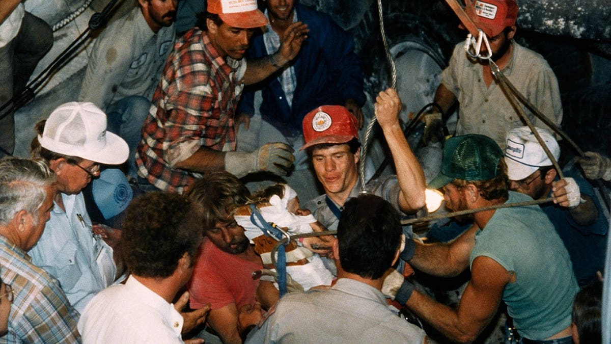 Rescuers work to free baby Jessica from narrow hole