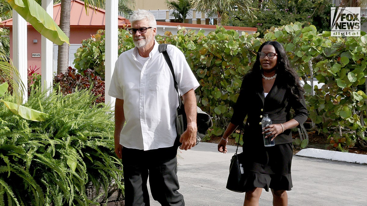Brian saliendo de un hotel en las Bahamas con su abogado