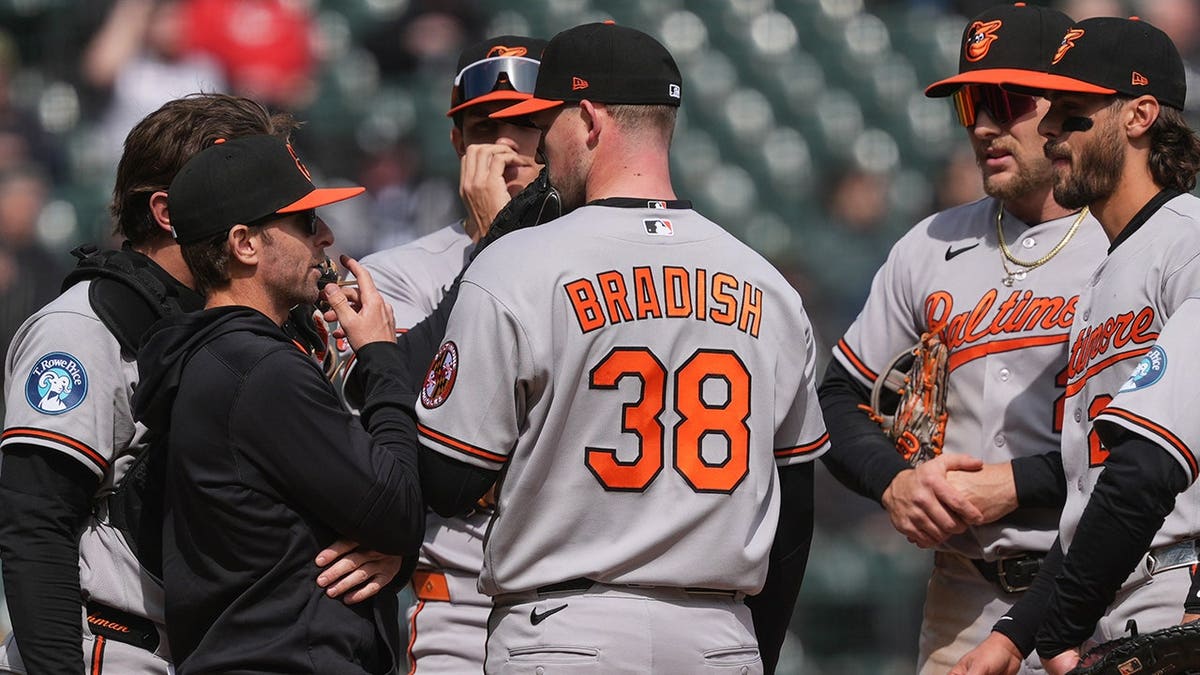 Baltimore Orioles manager Craig Albernaz talking with pitcher Kyle Bradish on the field