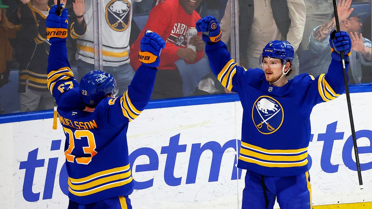 Buffalo Sabres defenseman Bowen Byram celebrating with defenseman Mattias Samuelsson on ice