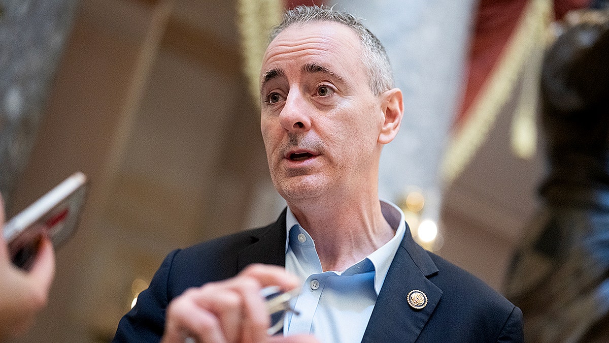 Brian Fitzpatrick speaking with a reporter while standing in the U.S. Capitol Statuary Hall.